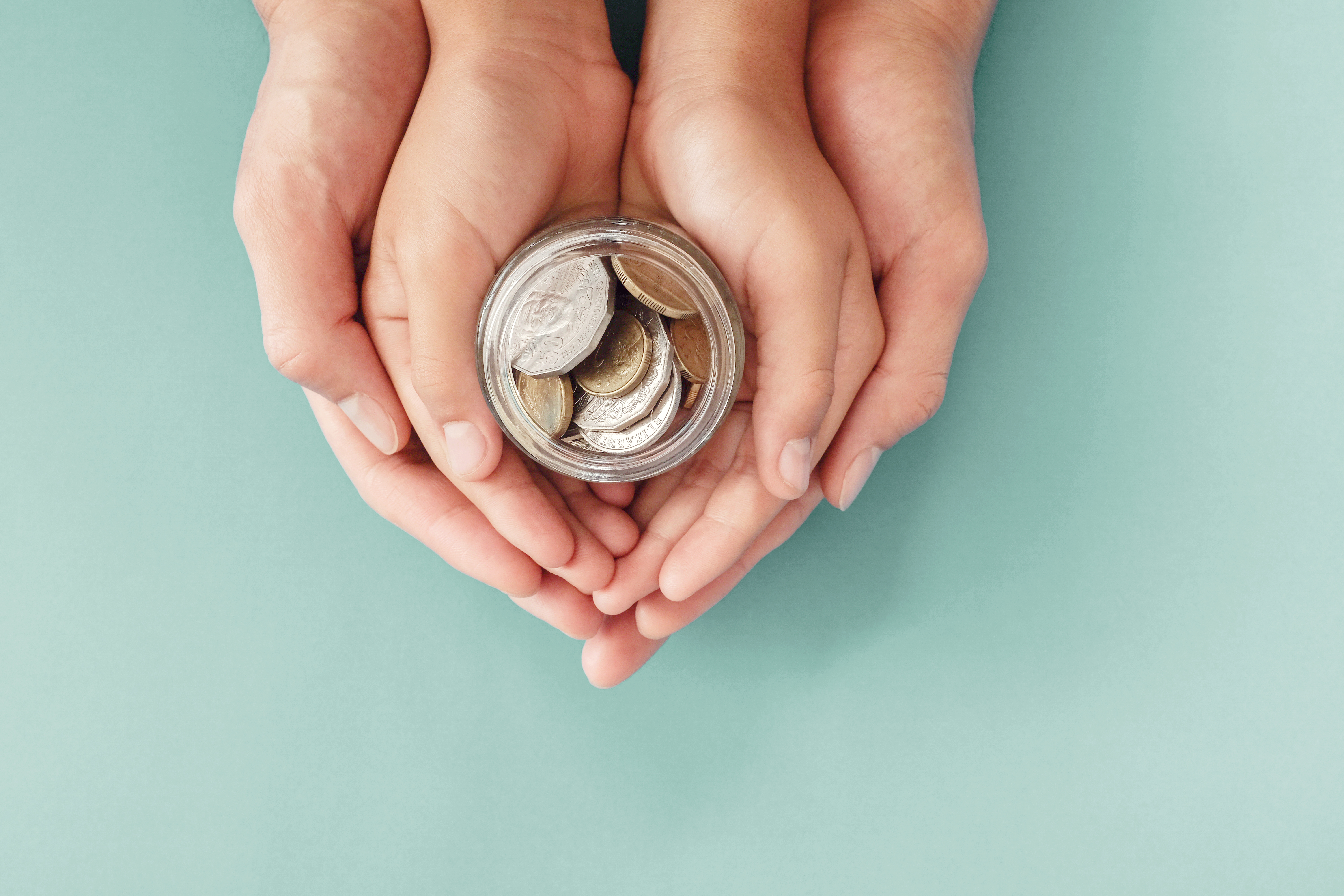 child-and-parent-hands-holding-money-jar-donation-saving-family-finance-plan-concept