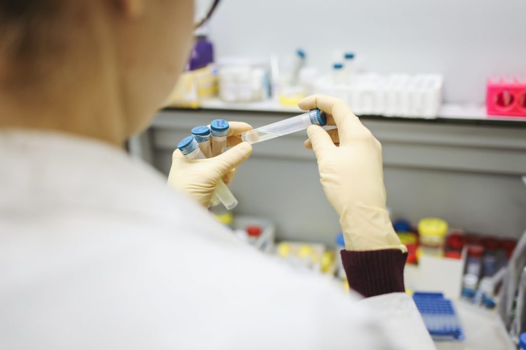 scientist in lab examines test tube