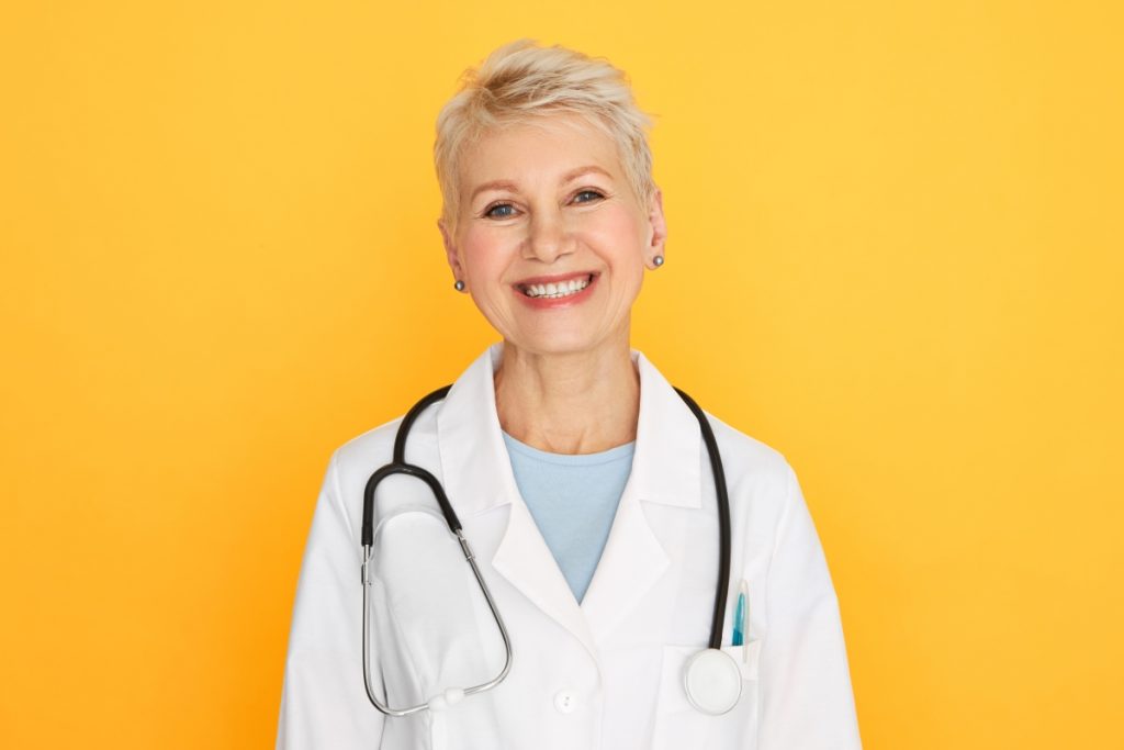 isolated-portrait-of-confident-experienced-middle-aged-female-doctor-with-short-blonde-haircut-looking-with-happy-smile