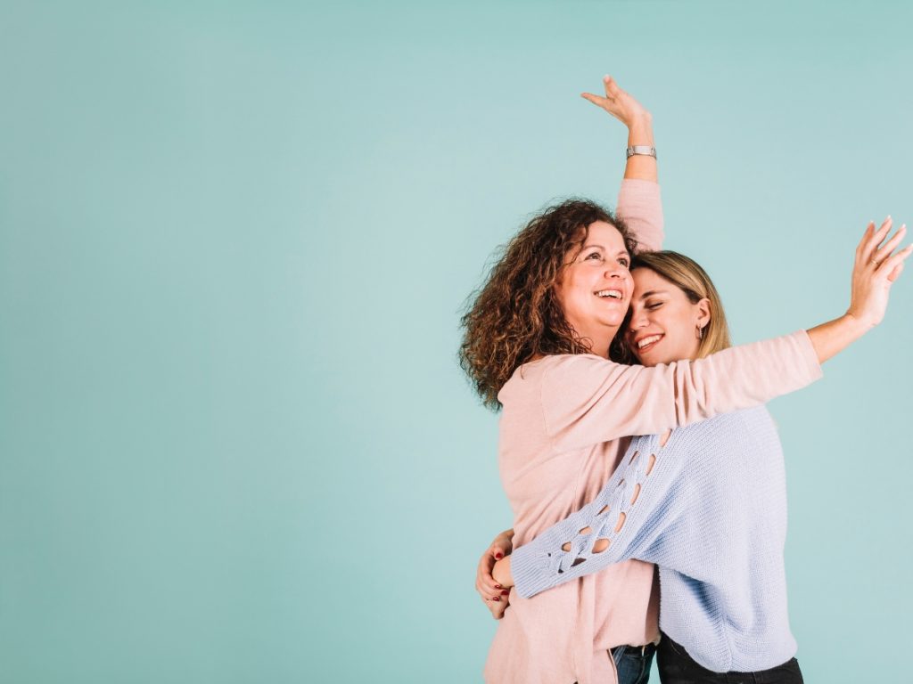 two happy women embracing hugging connecting